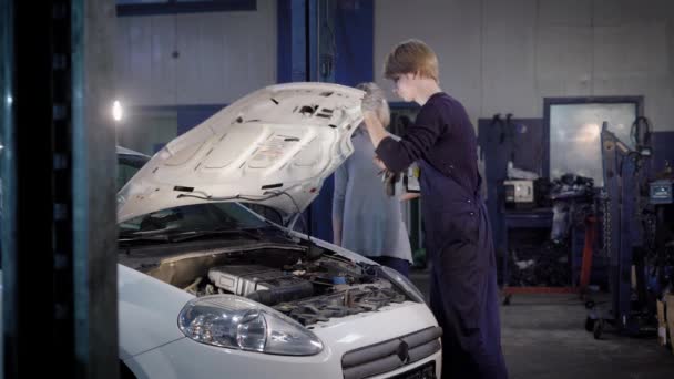 Mechaniker spricht mit einem Kunden am Auto — Stockvideo