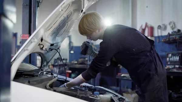 Garajda araç bakımı yapma teknisyen yan görünüm