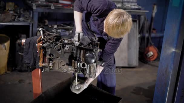 Un mecánico de automóviles joven y profesional trabaja en un taller de reparación de automóviles con un carburador con el fin de repostar y repararlo — Vídeos de Stock