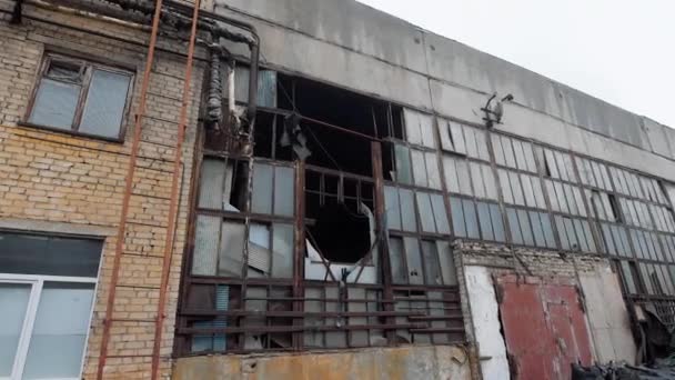 Фасад старого промышленного здания для сноса в пасмурный день, битое стекло и разрушенные рамы — стоковое видео