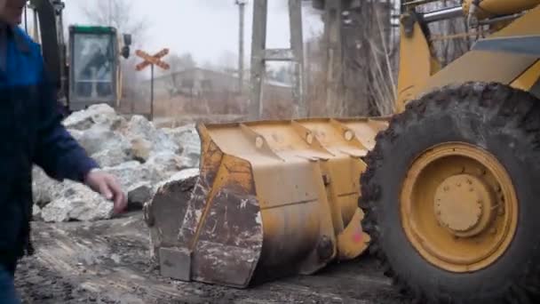 Bulldozer bewegt großes Stück Stein, Presslufthammer auf Basis von Traktor bricht Steine in Haufen im Freien, Bauschutt — Stockvideo