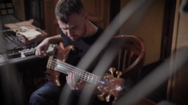 sakallı adam elektro gitar ses stüdyo kayıt, prova ve pratik karanlık odada plunking