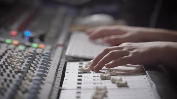 Geluidstechnicus is vermindering van signalen uit bronnen en effecten op een opgenomen geluid in een studio toepassen — Stockvideo