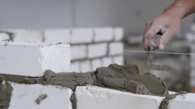 Kadeh beyaz tuğla duvar döşeme inşaat işçisi kapatmak.