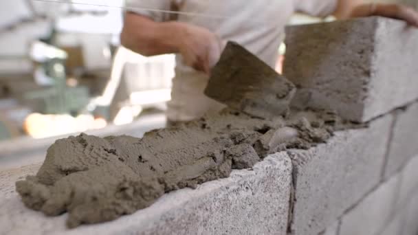 Närbild av en murare på en byggarbetsplats med en murslev — Stockvideo