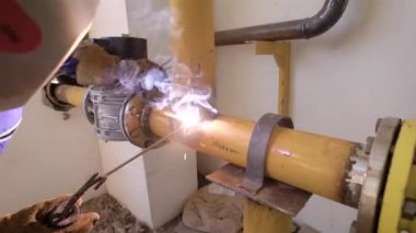 Koruyucu ekipman bir bitki üzerine metal boruları kaynak giyen sanayi işçisi.
