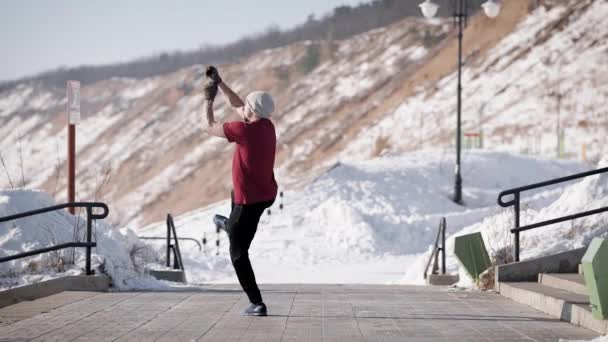 Energetischer junger Mann beim Low-Kick-Flip am Ufer im Winter. — Stockvideo