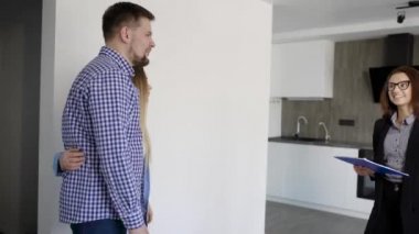 emlakçı kadın bir oturma odası ile mutfak girerek yeni düz genç evli çift gösterilen