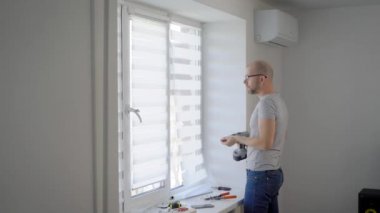 Ana pencere yükleme'de bir çerçeve içinde ev beyaz ışık oda içinde vida için dönme elektro tornavida kullanarak