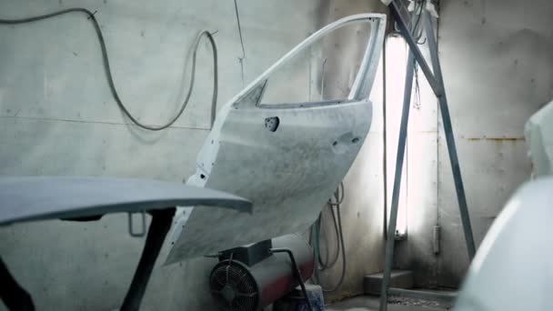 Araba parçaları, başlık ve kapıları ile bir oto tamircisi resim odasında Panoraması üzerinde duruyor sabitleme — Stok video