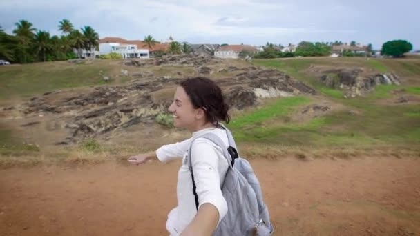 Inspirerat leende kvinna drar hand pojkvännen filmning och leder hans till kanten av klippa i en pittoresk tropisk skog i dag — Stockvideo