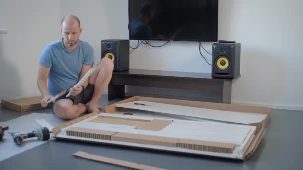 Handyman a acheté une nouvelle table pour sa maison et l'a déballer sur le sol . — Video