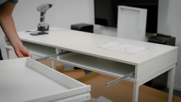 Close up shot of a repairmans hands assembling white table. — Stock Video