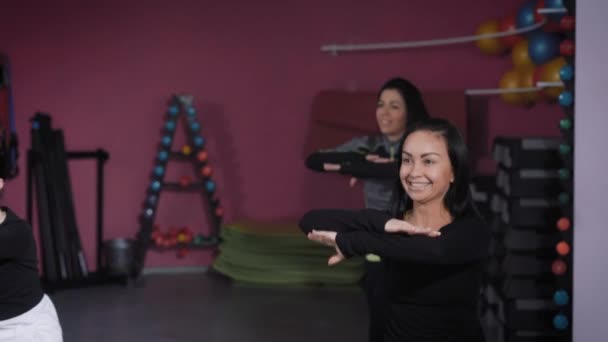 Groupe de sportives heureuses faisant de l'exercice dans un studio de fitness . — Video