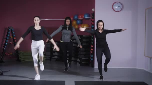 Tres mujeres atléticas usando ropa deportiva ejercitándose en un estudio especial . — Vídeos de Stock