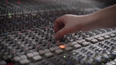 Müzisyen bir kayıt stüdyosu karıştırma konsolu ile çalışmaktadır.