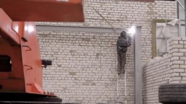 profesyonel bir işçi koruyucu üniformalı bir bina nesne kaynak olarak devreye girer, kişi bir tuğla duvar arka plan üzerinde