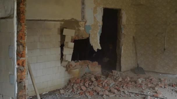 Process of destruction of a brick wall in the old house, inside the room there is a reconstruction or repair of a premise — Stock Video