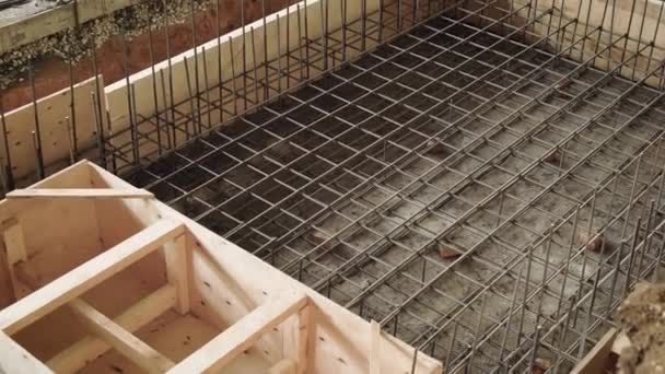 Ovanifrån av processen för formsättning av utrymme, byggare är engagerade i byggandet av en struktur av armerad betong — Stockvideo