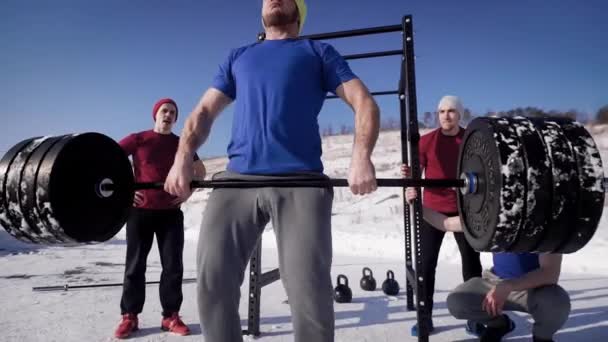 Os jovens entram para esportes na rua em um dia de inverno, os homens levantam o bar, em seguida, jogá-lo na distância ao ar livre — Vídeo de Stock