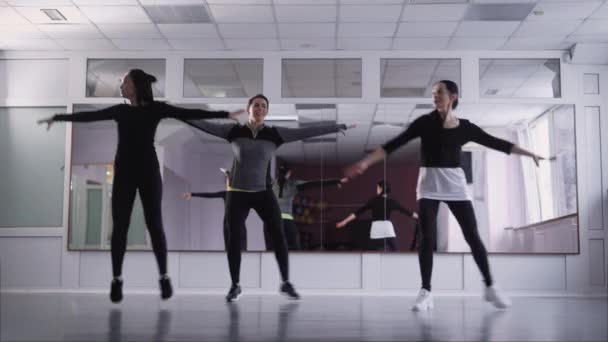 Um grupo de mulheres dança no ginásio uma dança esportiva enérgica, as senhoras de ternos são treinadas dentro de casa antes do desempenho — Vídeo de Stock