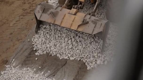 Вид зверху на важкий бульдозер, що рухає гравій на будівельному майданчику — стокове відео