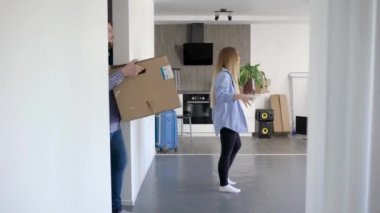 Mutlu genç çift tüm kutuları ve malzeme getiren yeni bir daire içinde hareket.