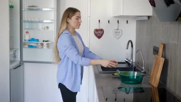 Genç ve güzel ev kadını mutfakta yemek için malzemeler hazırlanıyor. — Stok video