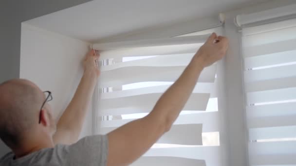 Nära upp skott av en man som du installerar nya persienner på hans fönster i lägenhet. — Stockvideo