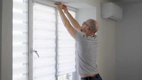 Reparador instalando nuevas persianas a rayas en una ventana en plano usando taladro . — Vídeo de stock