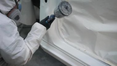 Bir garajda bir araba koruyucu Tekdüzen resim yan etek giyen adam görüntüsünü kapatmak.