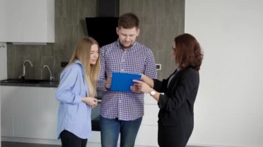 Erkek ve kadın kağıtları Emlakçı ile bir anlaşma ve daire kiralamak imzalama.