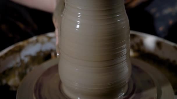 Close up tiro do vaso de argila, a matéria forma a forma do produto com a ajuda das mãos, o pote fica na roda oleiros — Vídeo de Stock