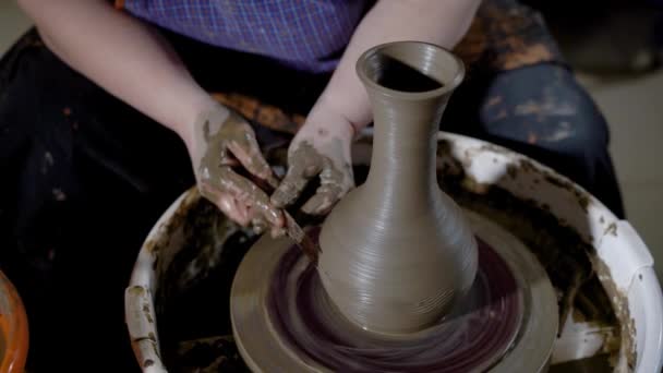 Крупним планом знімок жіночих рук, мати створює візерунок на глиняному горщику з інструментами, продукт стоїть на гончарному колесі — стокове відео
