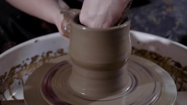 Close-up shot van de handen van een vrouw, die zich bezighoudt met aardewerk, een man wil een vaas van klei in de werkplaats — Stockvideo