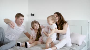 geleneksel evli çift yatak odasında tatil günlerinde çocuklarıyla birlikte vakit geçirmek, anne çocuk tutuyor