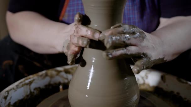 Mestre de produção de cerâmica manual está jogando e puxando argila para moldar paredes do vaso futuro para uma espessura uniforme em uma oficina — Vídeo de Stock