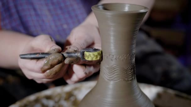 Meister der Keramikproduktion dekoriert frische Tonschüssel mit Ornament in einem Geschäft, mit rotierendem Rad mit Mustern — Stockvideo