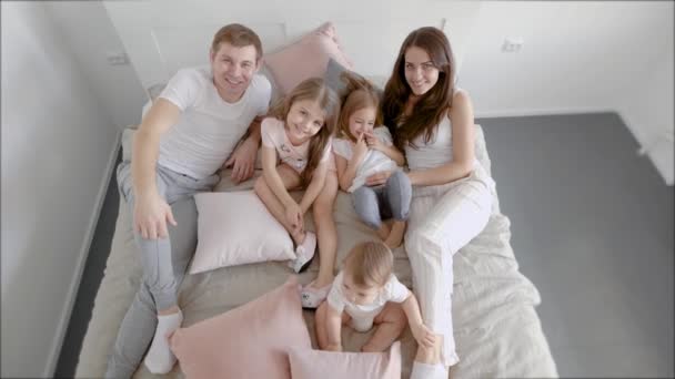 Tiro de cima de uma grande família feliz deitada na cama juntos no quarto . — Vídeo de Stock