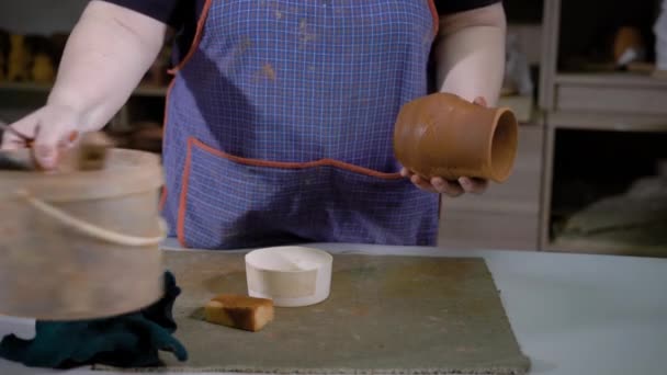 Handwerker putzt Vase aus frischem Ton in Töpferei — Stockvideo