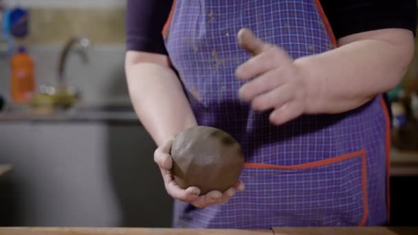 Close-up shot van een vrouwelijke ambachtsman vormen stukje klei in haar handen. — Stockvideo