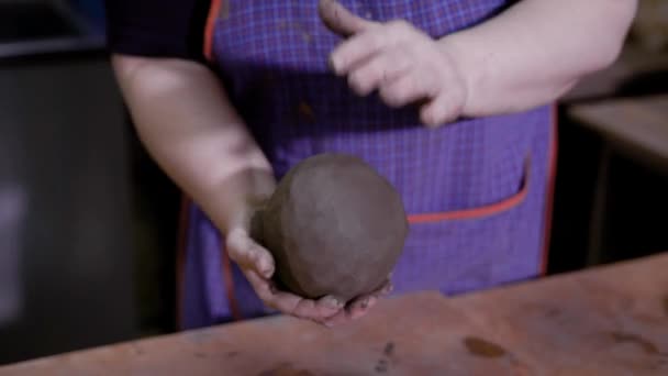 Close-up shot van een aardewerk meesters handen vormgeven van een grote bal uit klei. — Stockvideo