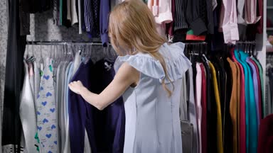 şık elbiseli bir genç bir kadın moda giysiler onu gardırobu için onu neşelendirmek için yardımcı olur alışveriş seçer