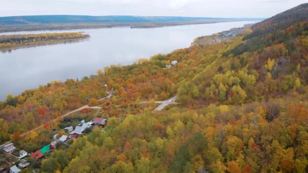 Luchtfoto 's. Herfst, een grote rivier tussen de bosheuvels. De bomen zijn al in gele en oranje bladeren. Seizoenen — Stockvideo