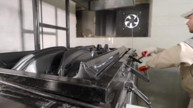 Bir erkek işçi üretim süreciyle meşgul. Bir adam plastik parçaların termo-vakum kalıbına hizmet eder..