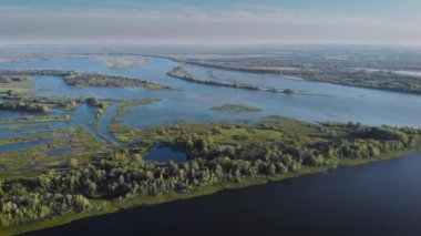 Güneşli bahar günlerinde, insansız hava aracından güzel bir sel çayırı manzarası, doğanın panoramik görüntüsü.