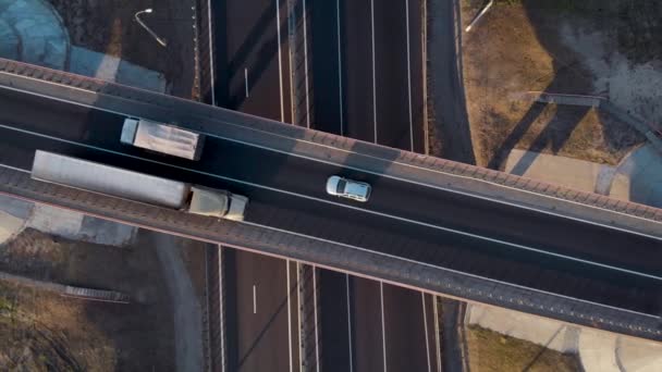 Aerial view. Interchange on the intercity highway. Cars and trucks travel in different directions. Two stripes in each direction. — Stock Video