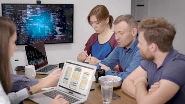 Jonge financiers op de bijeenkomst. Mannen en vrouwen bespreken de valutamarkt en de ontwikkelingsstrategie van de bedrijven. Veel indicatoren worden weergegeven in interactieve panelen. — Stockvideo