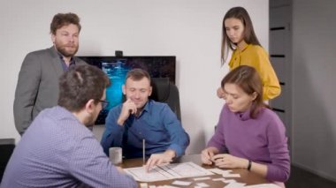 Beyin fırtınası. Çerçevede mobil uygulamanın tasarımcılarının elleri ve düzenleri var. Geliştiriciler tasarım aşamasında işlevsellik üzerine çalışırlar.