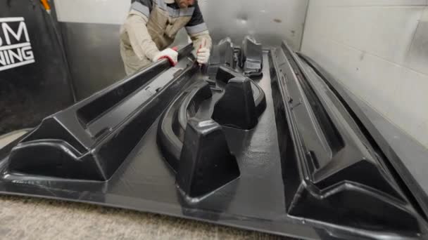 Ein männlicher Arbeiter schneidet Plastikteile aus. vakuumgeformte Formen von Automobilteilen. — Stockvideo